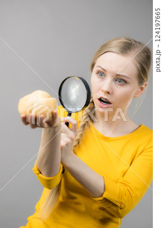 Shocked woman magnifying bun bread roll Shocked woman magnifying bun bread roll 124197665