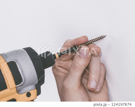 Person drilling in wall 124197674