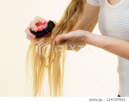 Blonde girl with long braid hair holds brush 124197681