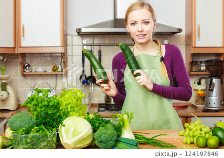Woman housewife in kitchen with green vegetables 124197846