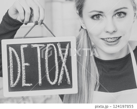 Happy woman holding board with detox sign 124197855