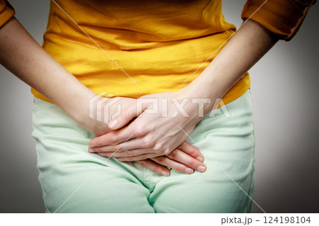 woman with hands holding her crotch 124198104