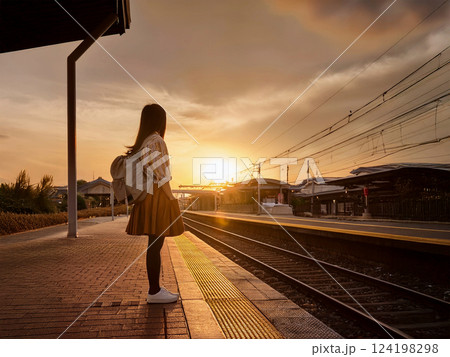 夕暮れの無人駅で列車を待つ学生 124198298
