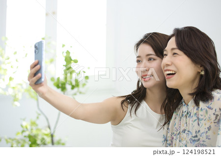 スマホを一緒に見るおしゃれな母と娘 124198521