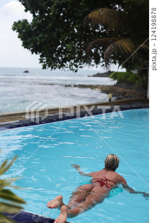 Enjoy a relaxing experience at the poolside while taking in the stunning ocean view nearby 124198878