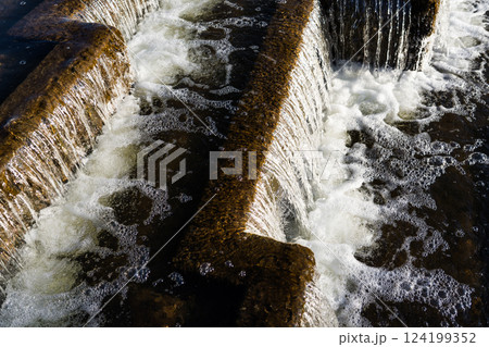 The waterfall is nearby. Falling water in a waterfall. Foam from the waterfall 124199352