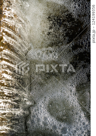 The waterfall is nearby. Falling water in a waterfall. Foam from the waterfall 124199356