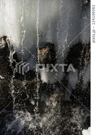 Water jets of a waterfall nearby. Waterfall in winter 124199362