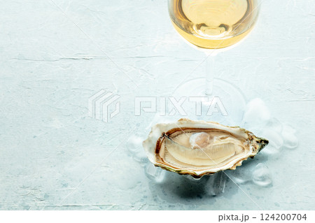 Oyster with a glass of wine, on ice, on a slate background Oyster with a glass of wine, on ice, on a slate background 124200704