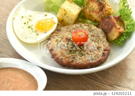 grilled black pepper pork collor steak and lettuce with tomato couple fried egg on plate dipping gravy sauce in cup 124201211