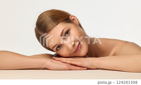 Portrait of beautiful young woman with healthy, smooth, clear skin gently posing against white studio background Portrait of beautiful young woman with healthy, smooth, clear skin gently posing against white studio background 124201308
