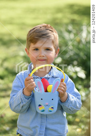 A boy looking for eggs in a bag for Easter 124201409