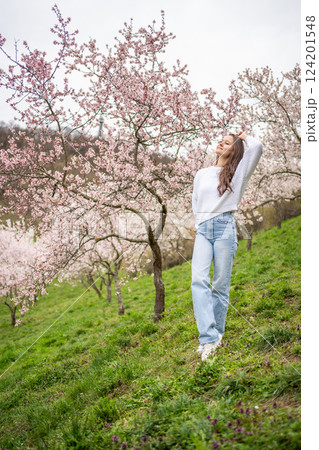 Lovely young woman in a blooming pink and white garden Petrin in Prague, spring time in Europe 124201548