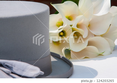 An Elegant Gray Hat paired with a White Calla Lily Bouquet creates a chic aesthetic An Elegant Gray Hat paired with a White Calla Lily Bouquet creates a chic aesthetic 124203265