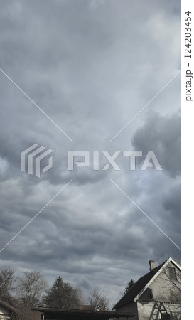 Blue sky with clouds, winter weather. Clouds on the background of trees. 124203454