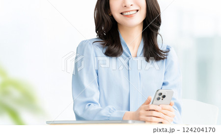 スマートフォンを持つ笑顔の女性・ビジネスウーマン スマートフォンを持つ笑顔の女性・ビジネスウーマン 124204170
