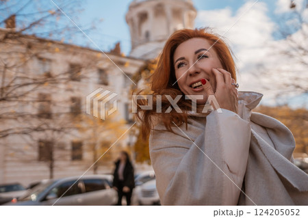 Woman, City, Autumn: Smiling redhead outdoors European city, fall season, joyful expression. 124205052