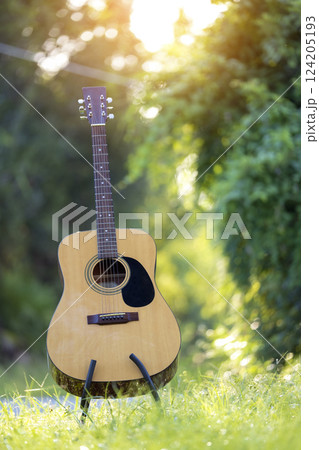 Acoustic guitar outdoors on greenery background. Concept of calm music 124205193