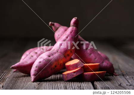 Heap of pink organic raw sweet potatoes on wooden rustic table 124205506