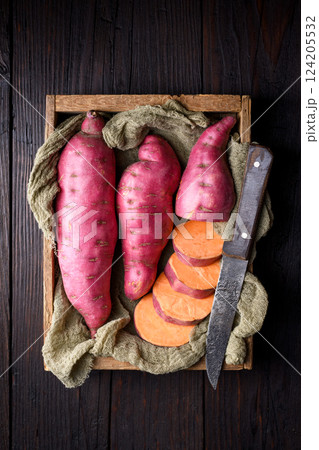 Top view of wooden box filled with pink organic raw sweet potatoes 124205532