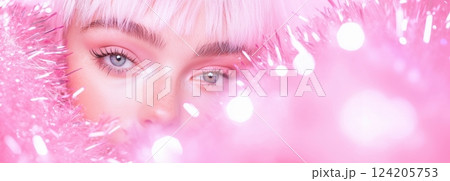 ピンクのポンポンの輝きに包まれる女性のクローズアップ 124205753