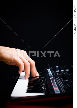 male hand playing on music synthesizer keyboard keys on black. music background 124205755
