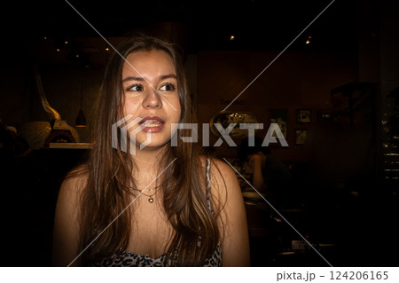A portrait of a sweet teenage Asian girl. Black background. A portrait of a sweet teenage Asian girl. Black background. 124206165