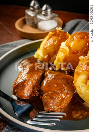 Traditional German braised pork cheeks in brown sauce. 124206265