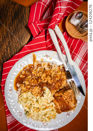 Braised pork in a spicy sauce served with bulgur and sauerkraut salad. 124206276