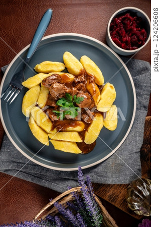 Beef stew in gravy served with potato dumplings. Beef stew in gravy served with potato dumplings. 124206608