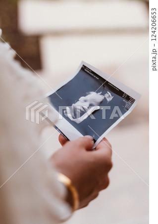 Person Holding an Ultrasound Photo of an Unborn Baby Person Holding an Ultrasound Photo of an Unborn Baby 124206653