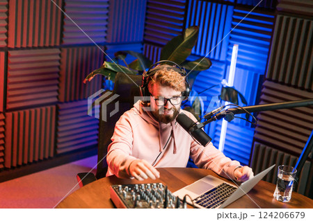 Handsome man radio DJ hosting a radio show, entertainment and communication concept 124206679