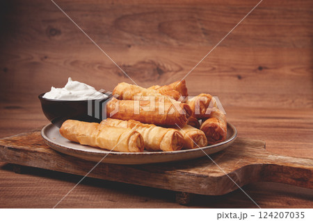 fried spring rolls with cheese, on a wooden background, with cream sauce, no people, fried spring rolls with cheese, on a wooden background, with cream sauce, no people, 124207035