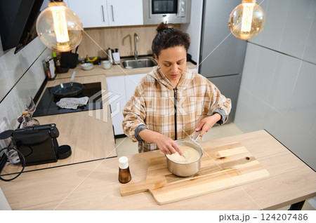 Woman Preparing Batter in a Modern Kitchen with Warm Lighting 124207486