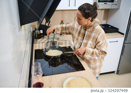Woman Cooking Crepes in a Modern Home Kitchen 124207499