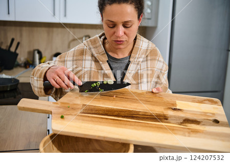 Woman Cooking in a Kitchen Preparing Fresh Ingredients for a Healthy Recipe 124207532