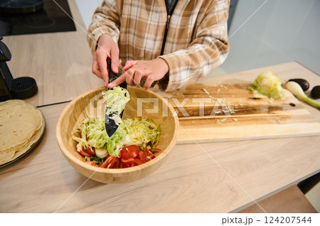 Preparing a Fresh Salad in a Cozy Home Kitchen Setting 124207544