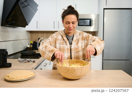 Woman Preparing Healthy Salad in a Home Kitchen Setting 124207567