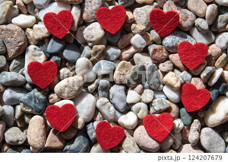 Circle of red bright fabric hearts on the much stones near the river. Circle of red bright fabric hearts on the much stones near the river. 124207679