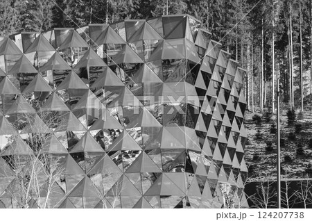 Modern architectural marvels reflect natures beauty amidst towering trees in a serene mountain landscape during bright daylight Modern architectural marvels reflect natures beauty amidst towering trees in a serene mountain landscape during bright daylight 124207738