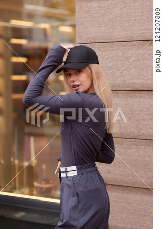 Young fashion blond woman in city park Stylish female model in white long sleeve shirt 124207809