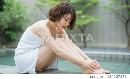 露天風呂の縁でくつろぐショートカットの女性 124207871