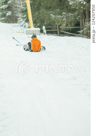 Winter wonderland adventure with snowboarder enjoying a thrilling descent on fresh snow amidst tall evergreen trees in a serene mountain landscape Winter wonderland adventure with snowboarder enjoying a thrilling descent on fresh snow amidst tall evergreen trees in a serene mountain landscape 124207950