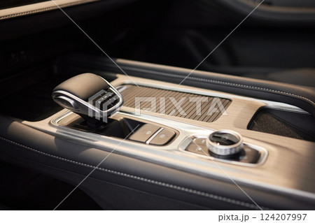 Selector automatic transmission with leather in the interior of a modern expensive car. The background is blurred. Black and brown leather car. Selector automatic transmission with leather in the interior of a modern expensive car. The background is blurred. Black and brown leather car. 124207997