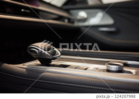 Selector automatic transmission with leather in the interior of a modern expensive car. The background is blurred. Black and brown leather car. Selector automatic transmission with leather in the interior of a modern expensive car. The background is blurred. Black and brown leather car. 124207998