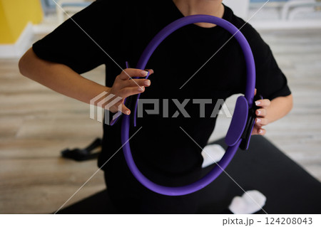 Young sporty attractive woman doing toning exercise for arms and shoulders with ring Young sporty attractive woman doing toning exercise for arms and shoulders with ring 124208043