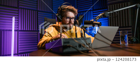 Banner Live streaming with smiling millennial man as radio presenter with microphone, talk show or entertainment. Male person content creator and happy on podcast host in studio for recording audio or 124208173