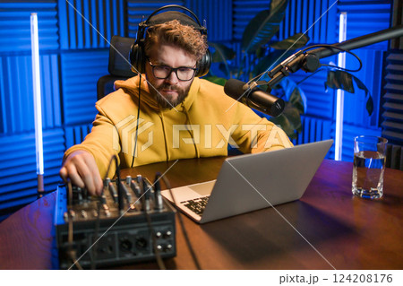 Handsome man radio DJ hosting a radio show, entertainment and communication concept 124208176