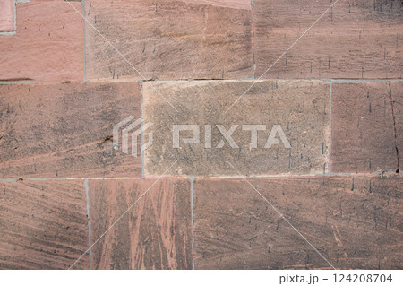 Structural stone wall of the ancient building consists of red big old bricks. Nature structural background. Structural stone wall of the ancient building consists of red big old bricks. Nature structural background. 124208704