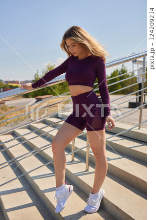 Portrait of fit and sporty young woman doing stretching in city. Portrait of fit and sporty young woman doing stretching in city. 124209214